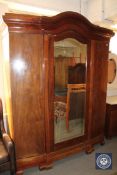 A continental mahogany triple door wardrobe