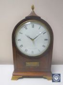 A 20th century inlaid mahogany mantel clock with lion mask handles by Comitti of London on brass