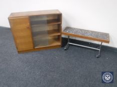A set of teak sliding glass door bookshelves fitted a cupboard together with a teak tiled top table