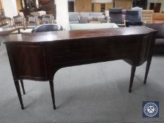 A shaped Regency style sideboard on tapered legs CONDITION REPORT: 195cm long by