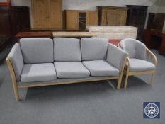 A blonde oak framed three seater settee and armchair with grey cushions