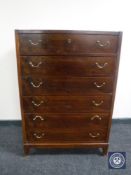 A mid twentieth century teak six drawer chest with brass drop handles