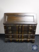 A continental oak serpentine fronted bureau