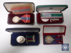 A collection of four medals on ribbons - Imperial service medal, long service defence medal,