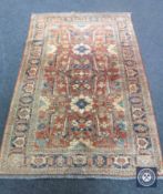 A fringed Persian rug of geometric design