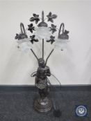 An ornate three-way lamp modelled as a lady holding a basket