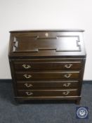 A twentieth century oak bureau fitted with four drawers