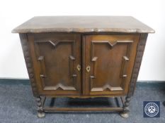 A twentieth century oak double door cabinet on bobbin legs