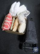 A trolley containing cushions together with two further boxes containing table linen and cushions
