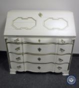 An antique hand painted cream and gilt serpentine fronted bureau