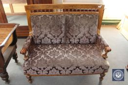 An antique inlaid walnut framed settee in purple brocade fabric