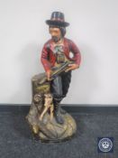 A painted wooden figure of a huntsman with dog