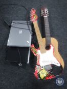 A child's electric guitar together with an acoustic guitar and two laptops