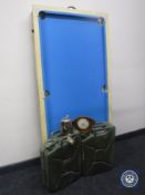 A folding pool table with accessories, two metal jerry cans,