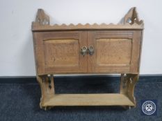 An Edwardian oak double door wall cabinet with shelf