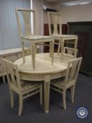 A white and gilt oval extending painted table with six chairs