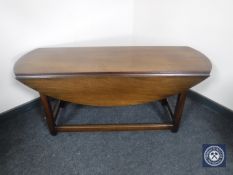 A narrow mahogany drop leaf table