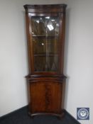 An inlaid mahogany inverted-bowed corner display cabinet