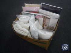 A box of new bedding, net curtains, linen etc.