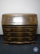 A continental oak serpentine fronted bureau