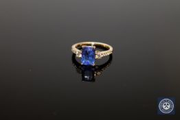 An 18ct yellow gold tanzanite and diamond ring, the cushion-cut medium blue tanzanite weighing 2.