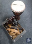 A box of carved wooden animal figure, tribal drum etc.