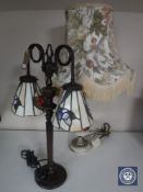 A metal table lamp with two Tiffany style shades together with a brass and marble table lamp with