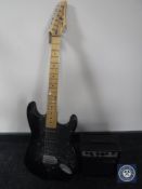 A Sunn Mustang electric guitar together with a mini guitar amplifier and acoustic guitar in carry