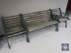 A wrought iron and wood three piece garden furniture set comprising bench and two armchairs