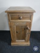 A pine pot cupboard fitted with a drawer