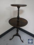 A mahogany two-tier wine table on tripod base