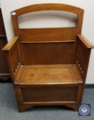 An Edwardian oak storage settle of neat proportions,