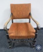 A carved oak scroll arm armchair