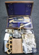 A tray of plated and stainless steel cutlery, napkin rings,