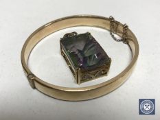 A gilt bangle and a 9ct gold mounted pendant