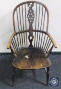 An antique elm kitchen armchair