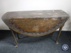A 19th century carved oak gateleg table on club feet