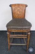 A breakfast bar stool with tooled leather panelled back