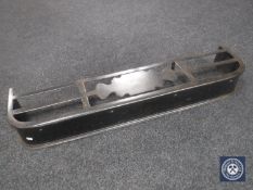 An antique metal fire curb