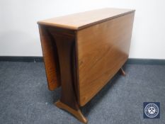 A narrow teak drop leaf table