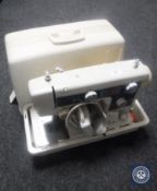 A cased New Home electric sewing machine with foot pedal