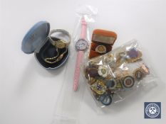 A box containing a quantity of enamel badges, silver gilt ring,