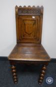 An Edwardian oak hall chair on turned legs