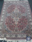 A Persian style fringed rug on pink ground