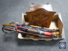 A wall cabinet and assorted umbrellas and sticks
