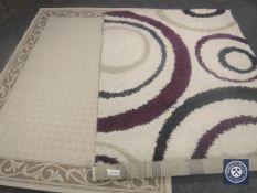 Two contemporary rugs together with a blue glass vase containing artificial flowers