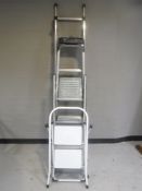 A bundle of garden tools together with four assorted sets of folding steps