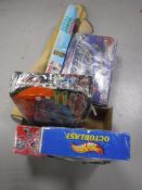 A box containing Hot Wheels, race set, champion deluxe race set, remote control helicopter,