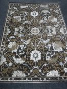 A contemporary floral rug on brown ground 170cm by 120cm
