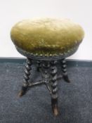 A Victorian circular adjustable piano stool on barley twist legs